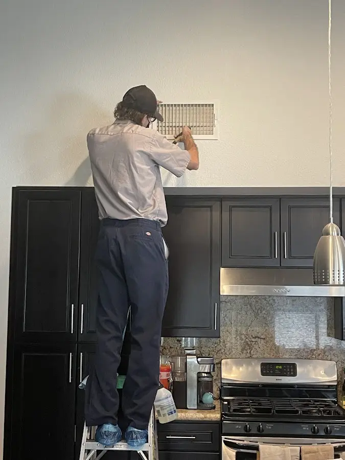Technician inspecting an air vent during HVAC service in River Vale